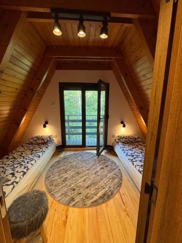 a attic room with two beds and a large window at Vila Eden Rudnik in Rudnik Kačerski
