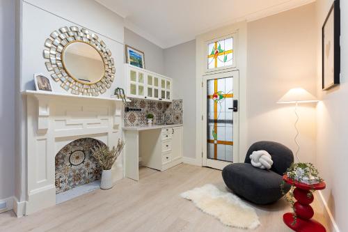 een woonkamer met een stoel en een spiegel bij Trendy 4BR Petersham Stay Steps from Top Cafés in Sydney