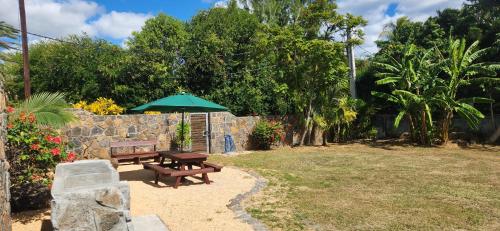 a park with a bench and an umbrella at La Maison d'Isa in Albion