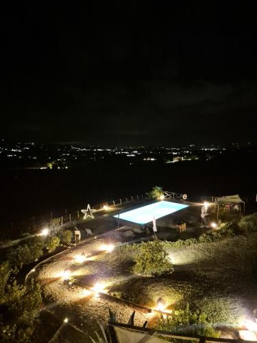 a swimming pool at night with lights at Casale Delle Stelle in Castello delle Forme