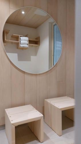 a bathroom with a mirror and a bench and a table at Villa Vaalea in Rovaniemi