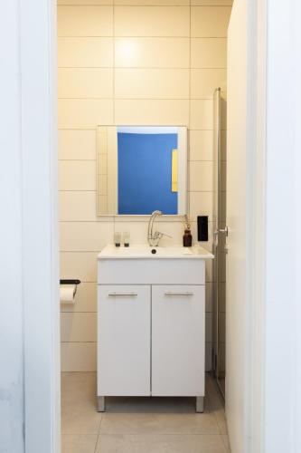 a bathroom with a white sink and a mirror at Rena's House - Beach Edition in Tel Aviv