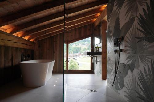 a bathroom with a tub and a large window at CHALET TEKA LES GETS - Appartement Duplex in Les Gets
