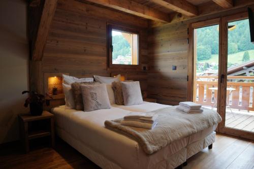 a bedroom with a bed in a log cabin at CHALET TEKA LES GETS - Appartement Duplex in Les Gets