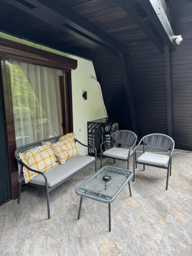 three chairs and a couch and a table on a porch at Vila Eden Rudnik in Rudnik Kačerski