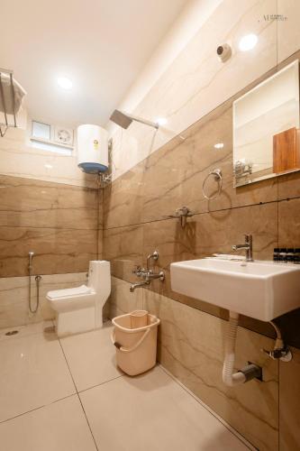 a bathroom with a sink and a toilet at The Aetheria Service Apartment in Chikmagalūr