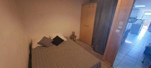 - un petit lit avec deux oreillers dans l'établissement maison en bord de mer, à L'Aiguillon-la-Presqu'île