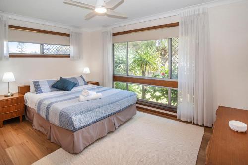 a bedroom with a bed and a large window at Busselton Jetty Heritage House in Busselton