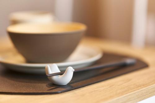 a wooden table with a spoon and a cup of coffee at Asagaya House in Tokyo