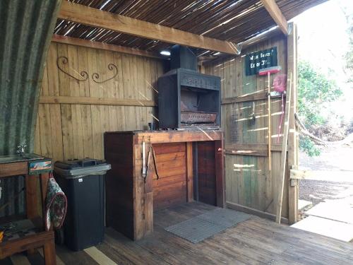 an outdoor kitchen with a stove in a wooden cabin at 11 Mountain Stream Hot Tub Self Catering in Gordonʼs Bay