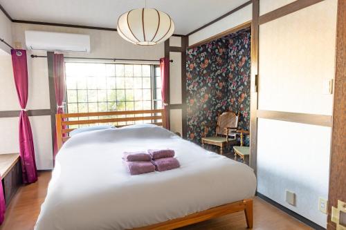une chambre avec un grand lit blanc et une fenêtre dans l'établissement Cottage Atami-Momoyama-Town コテージ熱海桃山町, à Atami