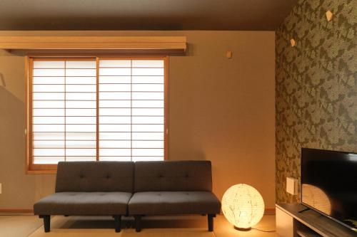 a living room with a couch in front of a window at Asagaya House in Tokyo
