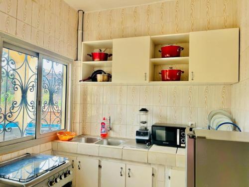 a kitchen with a sink and a microwave at EDEN Restorer in Yaoundé