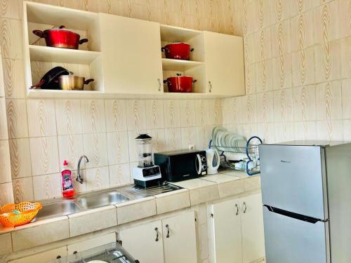 a kitchen with a sink and a refrigerator at EDEN Restorer in Yaoundé
