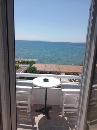 a table on a balcony with a view of the ocean at Studios Margarita in Platis Yialos Sifnos