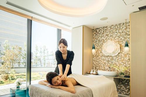 a woman standing on a bed with a woman laying on it at Centara Grand Hotel Osaka in Osaka