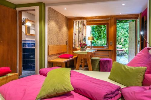 a bedroom with pink and green pillows on a bed at Hotel Schmausemühle in Gondershausen