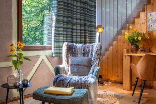 a blue chair sitting in a room with a window at Hotel Schmausemühle in Gondershausen