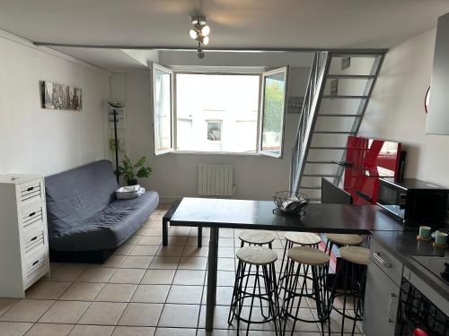 une cuisine et un salon avec une table et un canapé dans l'établissement Appartement T3 tout confort en duplex à 20mn à pied du centre-ville avec TV et Wifi, à La Rochelle