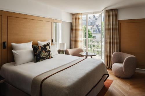 a bedroom with a large bed and a balcony at Hôtel De Sers Champs Elysées Paris in Paris