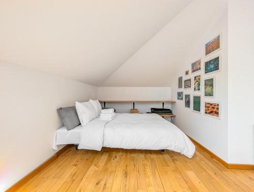 a white bedroom with a white bed and wooden floors at Trawowa Spacious House by BookingHost in Wrocław