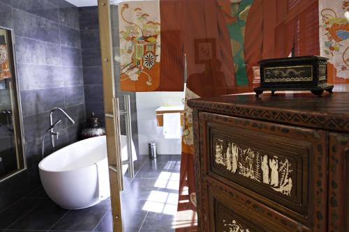 La salle de bains est pourvue d'une baignoire, de toilettes et d'un lavabo. dans l'établissement La Belle Meuniere, à Royat