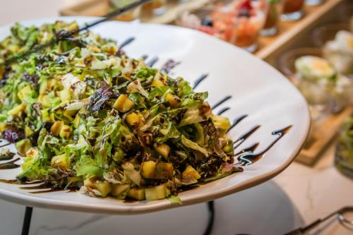 a salad on a white plate with a fork at Hotel Mercury by ALEGRIA in Santa Susanna