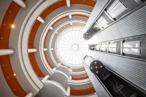 a spiral staircase in a building with a large window at Hotel Mercury by ALEGRIA in Santa Susanna