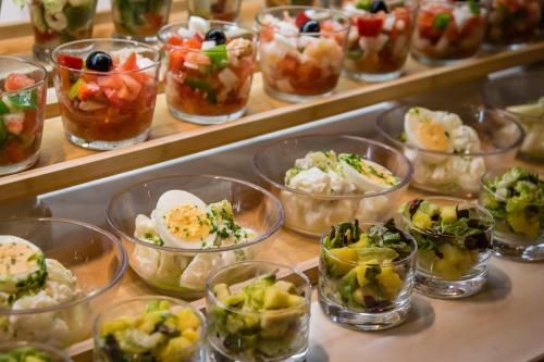 a bunch of bowls filled with different types of food at Hotel Mercury by ALEGRIA in Santa Susanna