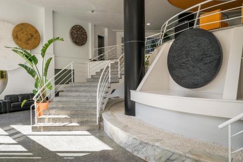 a spiral staircase in a house with a black pole at Hotel Mercury by ALEGRIA in Santa Susanna