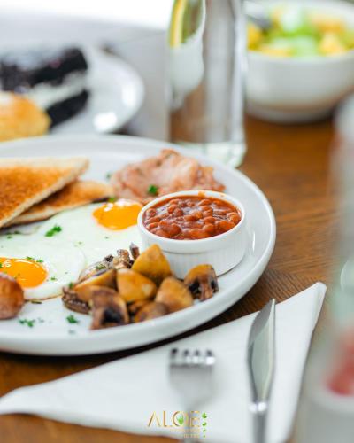 een bord ontbijtproducten met eieren en toast bij Aloe Lifestyle Hotel in Eshowe