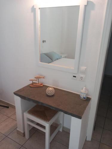 a dressing table with a mirror and a stool at Studios Margarita in Platis Yialos Sifnos