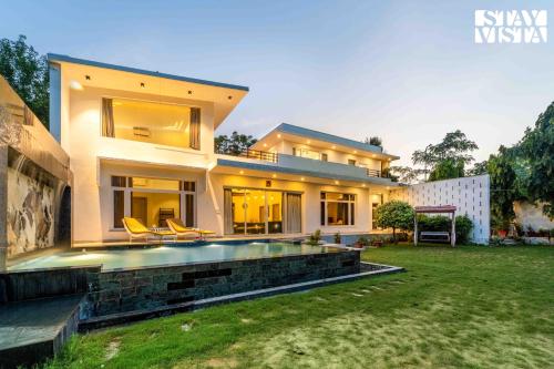 a house with a swimming pool in a yard at StayVista at Kuber Vatika with BBQ & Bonfire in Jaipur