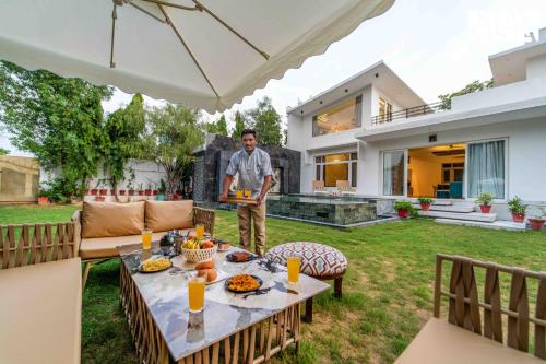 a man standing in the backyard of a house at StayVista at Kuber Vatika with BBQ & Bonfire in Jaipur