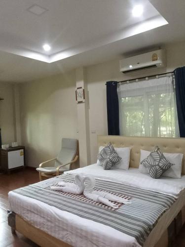 a bedroom with a large bed with towels on it at Sripiamsuk Resort Bangkok in Pathum Thani