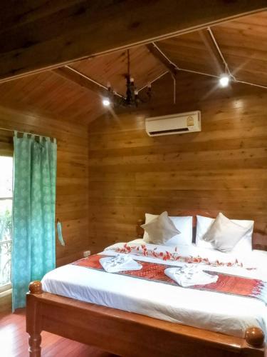 a bedroom with a bed in a wooden room at Sripiamsuk Resort Bangkok in Pathum Thani
