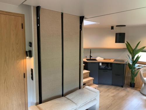 a living room with a couch and a kitchen at The Nutshell met hottub en sauna | 2 personen in Neede