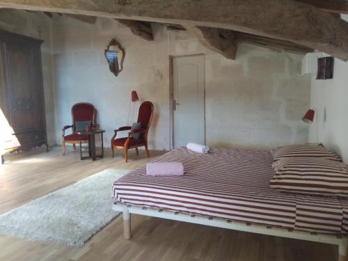 une chambre avec un lit, deux chaises et une table dans l'établissement Ancien Couvent avec piscine entre Alpilles et Camargue pour 10 personnes, à Arles