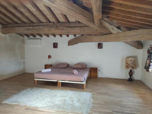 une chambre avec un lit dans une pièce avec des plafonds en bois dans l'établissement Ancien Couvent avec piscine entre Alpilles et Camargue pour 10 personnes, à Arles