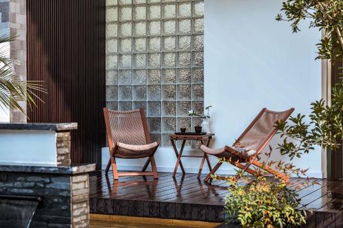 two chairs sitting on a porch with a fireplace at 山也云也大理古城南门店 in Dali Ancient Town