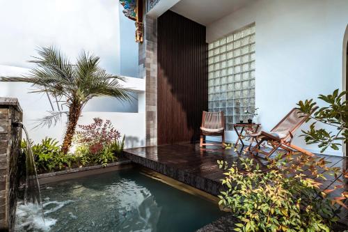 a swimming pool in the middle of a garden with two chairs at 山也云也大理古城南门店 in Dali Ancient Town