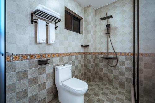 a bathroom with a toilet and a shower at 山也云也大理古城南门店 in Dali Ancient Town