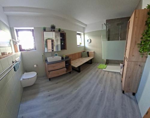 a bathroom with a sink and a toilet and a tub at Modernes Appartement nur 5 km von Erfurt, stilvoll komfortabel und perfekt angebunden, Kaffeevollautomat, TV, WLAN, Schlafsofa und Einkaufsmöglichkeiten in der Nähe, hervorragende Anbindung zur A4 und A71, kostenlose öff Parkplätze für PKW und Transporter in Elxleben