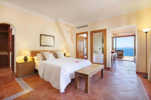 a bedroom with a bed and a view of the ocean at Escape to Luxury: Rent Mallorca Villa 1452 in Cala Vinyes