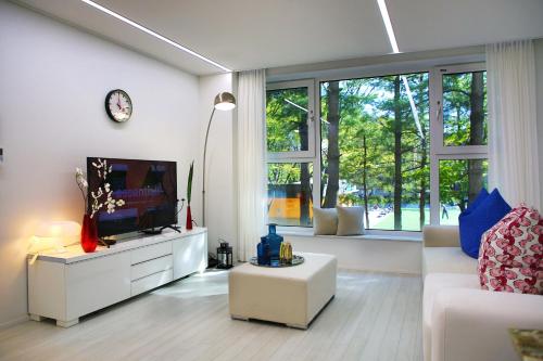 a living room with a tv and a white couch at Stay Park 1 in Goyang