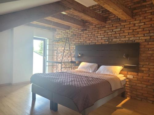 Un dormitorio con una pared de ladrillo y una cama. en Villa Rustica, 