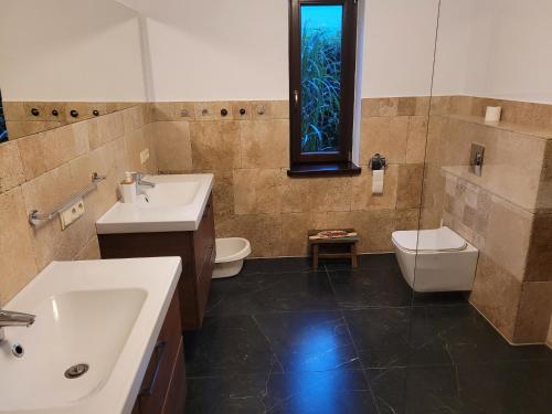 Un baño con dos lavabos y un inodoro y una ventana. en Villa Rustica, 
