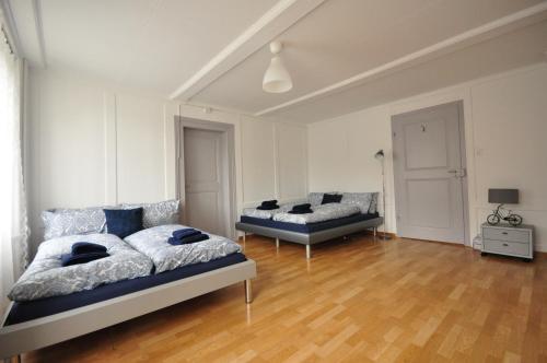 a bedroom with two beds and a wooden floor at Townhouse II Sleeps 12 guests Central in Interlaken