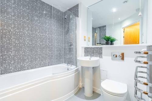 Un baño con bañera, lavabo e inodoro. en Cotels Centro - CENTRAL LOCATION, PARKING, FIBRE WIFI, SMART TV, FULLY EQUIPPED KITCHEN, en Northampton