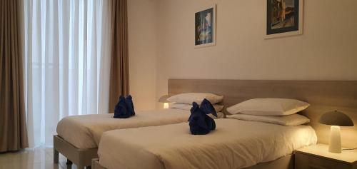 two beds in a hotel room with two bags on them at Horizon Residence in Ix-Xagħra taʼ Barra